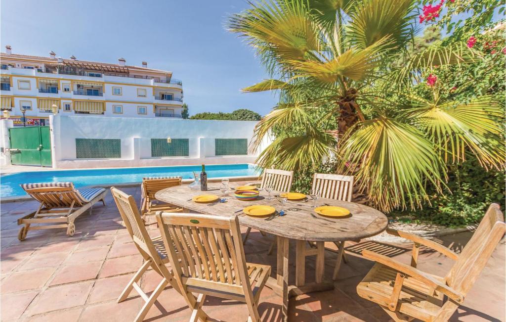 drewniany stół i krzesła na patio w obiekcie 7 Bedroom Amazing Home In Mijas Costa w mieście La Cala de Mijas