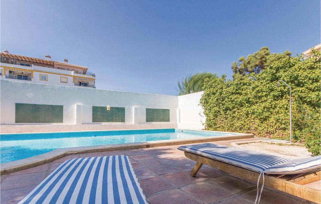 basen z ławką obok budynku w obiekcie 7 Bedroom Amazing Home In Mijas Costa w mieście La Cala de Mijas