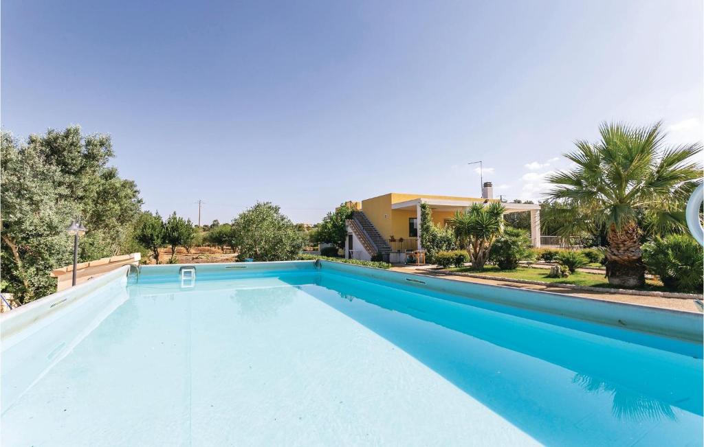 een groot blauw zwembad met een huis op de achtergrond bij Villa Betty in Scuola