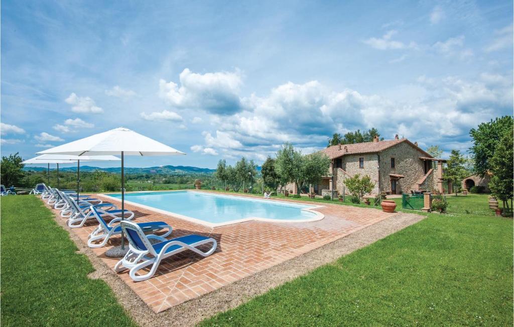 a swimming pool with lounge chairs and an umbrella at Cortilla 3 in Cinigiano
