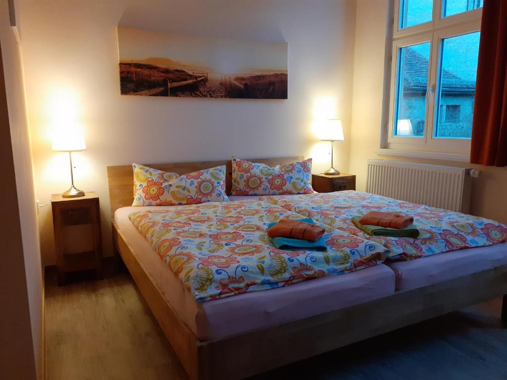 1 dormitorio con 1 cama con almohadas y 2 lámparas en Altstadtidylle Allerheiligen en Erfurt