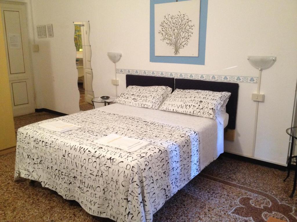 um quarto com uma cama com uma colcha preta e branca em Albergo Novecento em Gênova