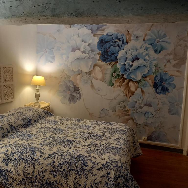 - une chambre avec une fresque murale florale dans l'établissement L'OCCITANE appartement climatisé centre ville, à Limoux
