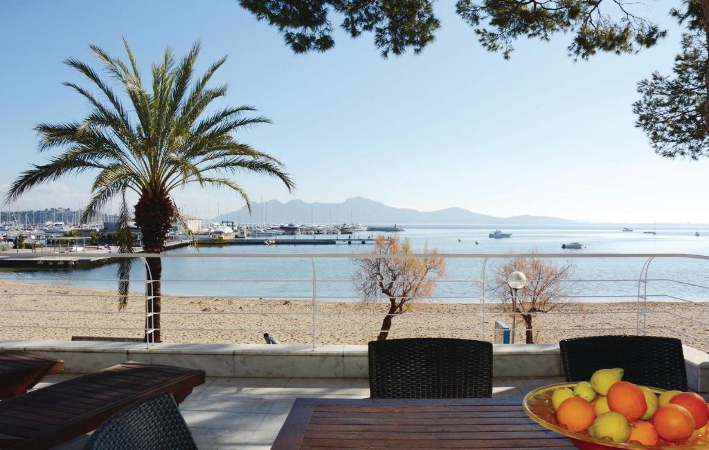 a bowl of fruit sitting on a table next to a beach at Awesome Apartment In Port De Pollença in Port de Pollensa