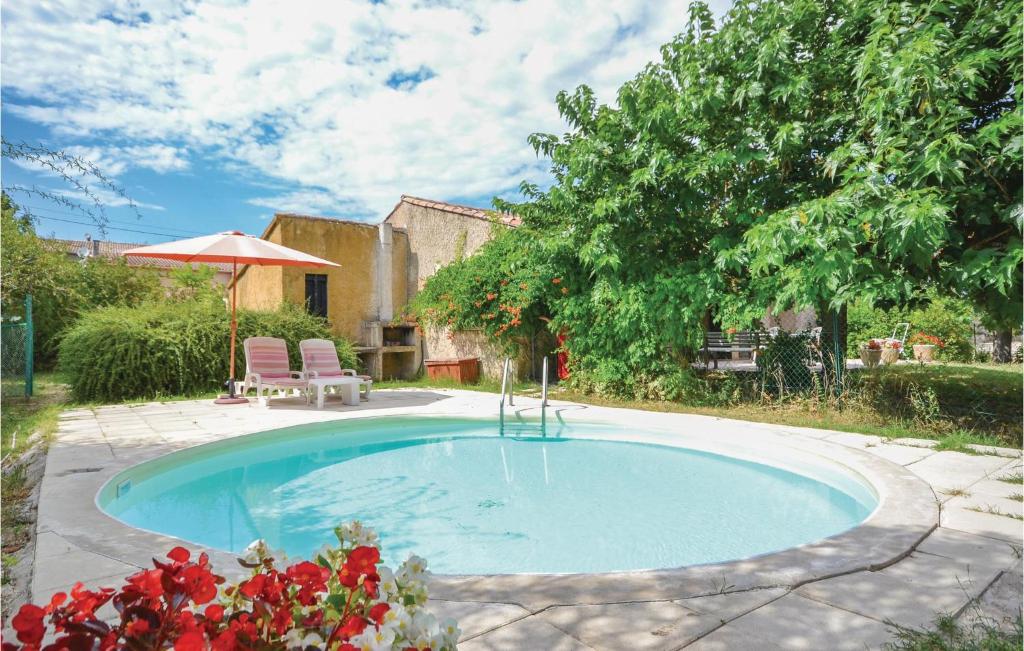 a swimming pool with two chairs and an umbrella at Mas Mirasol in Gargas