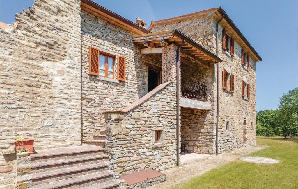 a stone house with a staircase on the side of it at Poggio Vecchio in Molino Moscano