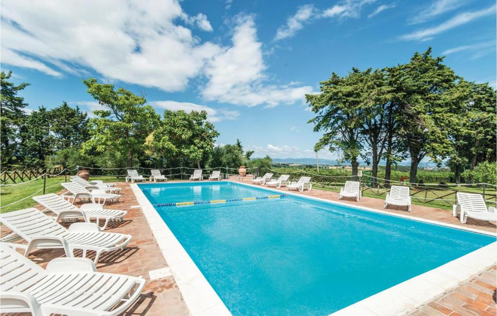 een zwembad met ligstoelen en stoelen eromheen bij Stunning Apartment In Castiglione D,lago Pg With 2 Bedrooms, Wifi And Outdoor Swimming Pool in Strada