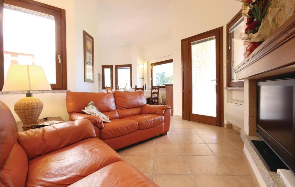 salon ze skórzaną kanapą i telewizorem w obiekcie Cozy Home In Costa Rei -Ca- With Wifi w mieście Monte Nai