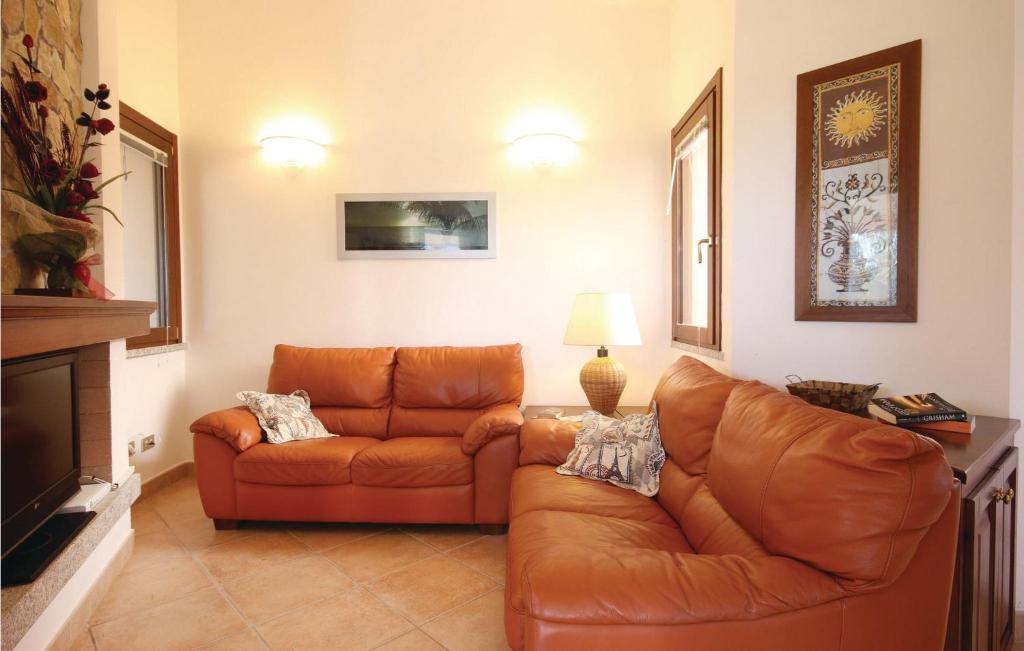 salon ze skórzaną kanapą i lampą w obiekcie Cozy Home In Costa Rei -Ca- With Wifi w mieście Monte Nai