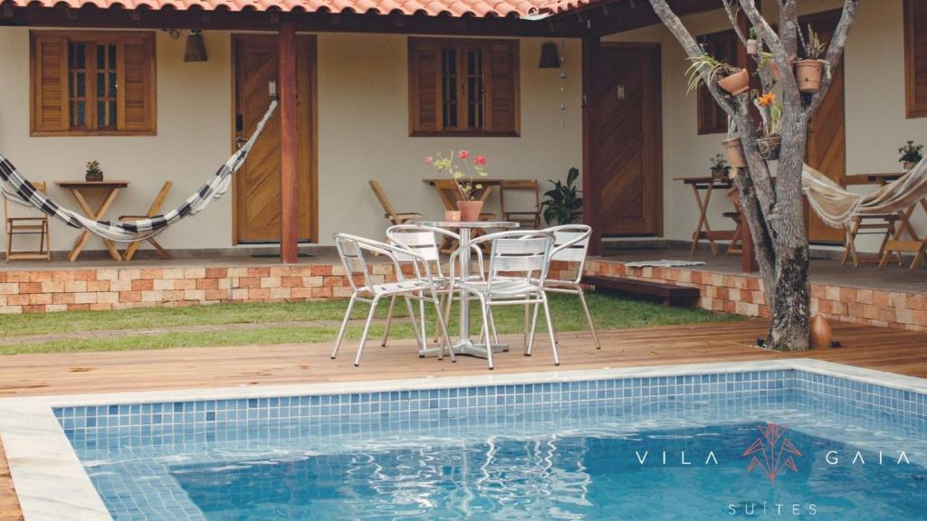 een patio met een tafel en stoelen naast een zwembad bij Vila Bonita in Alto Paraíso de Goiás