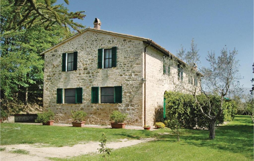 ベヴァーニャにあるVigna Dの緑の窓が付いた古い石造りの家
