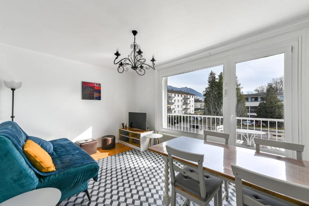 uma sala de estar com um sofá, uma mesa e uma janela em Le Boileau - Apartment for 4 people parking and balcony CLOSE to the Lake em Annecy