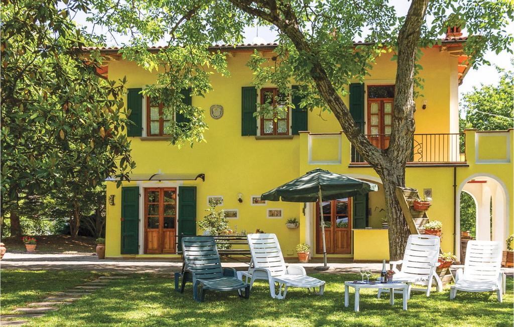 un gruppo di sedie e un ombrellone di fronte a una casa di Stunning Home In Partina Ar With 5 Bedrooms And Wifi a Soci