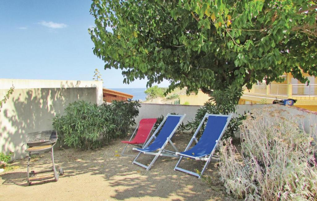 three blue and red chairs sitting next to a wall at Beautiful Apartment In Calvi With 3 Bedrooms in Calvi