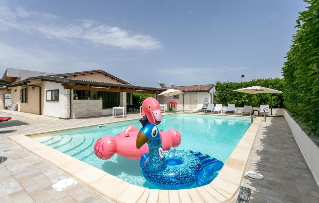 uma piscina com uma piscina insuflável rosa no meio em 4 Bedroom Cozy Home In Punta Cirica em Santa Maria Del Focallo