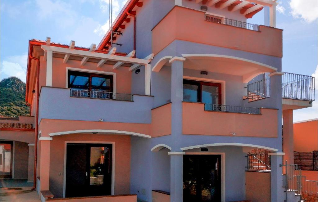 um edifício laranja e branco com janelas e varandas em Mari E Monti em Badesi