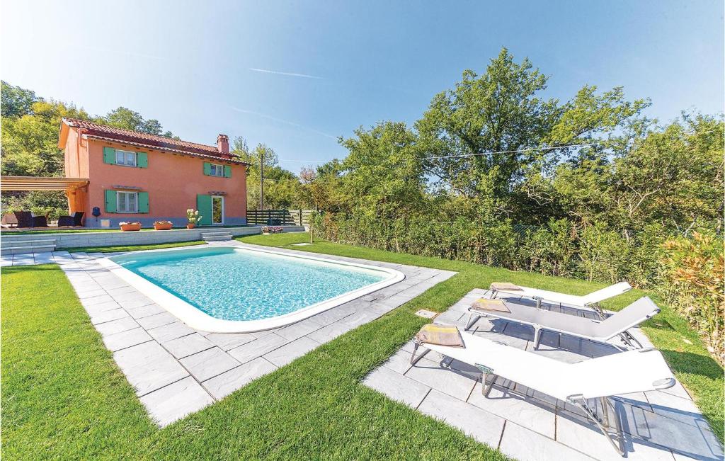 a swimming pool with two chairs and a house at La Casetta in Marcoiano