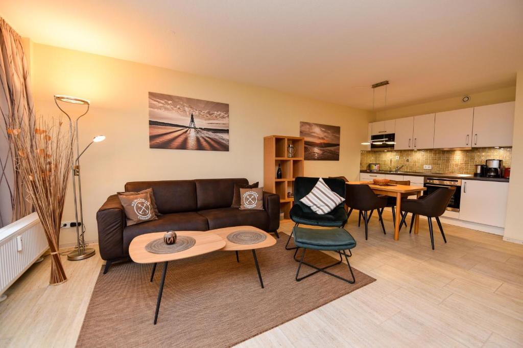 a living room with a couch and a table at Haus "Panorama" Appartement PAN068 in Duhnen