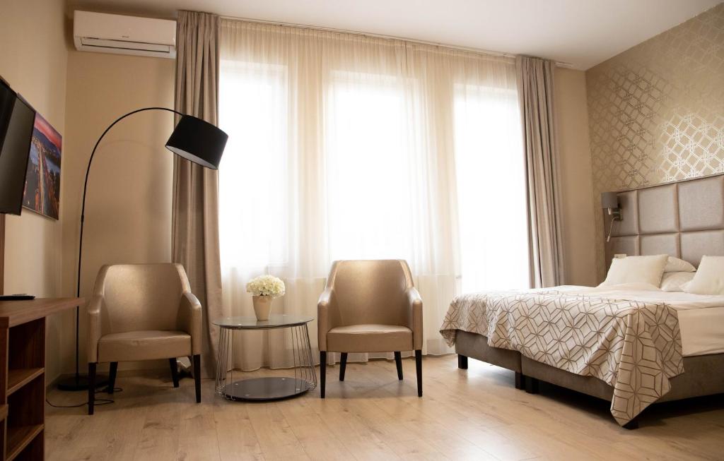 1 dormitorio con 1 cama, 2 sillas y mesa en Vánkos & Eszcájg, en Újhartyán