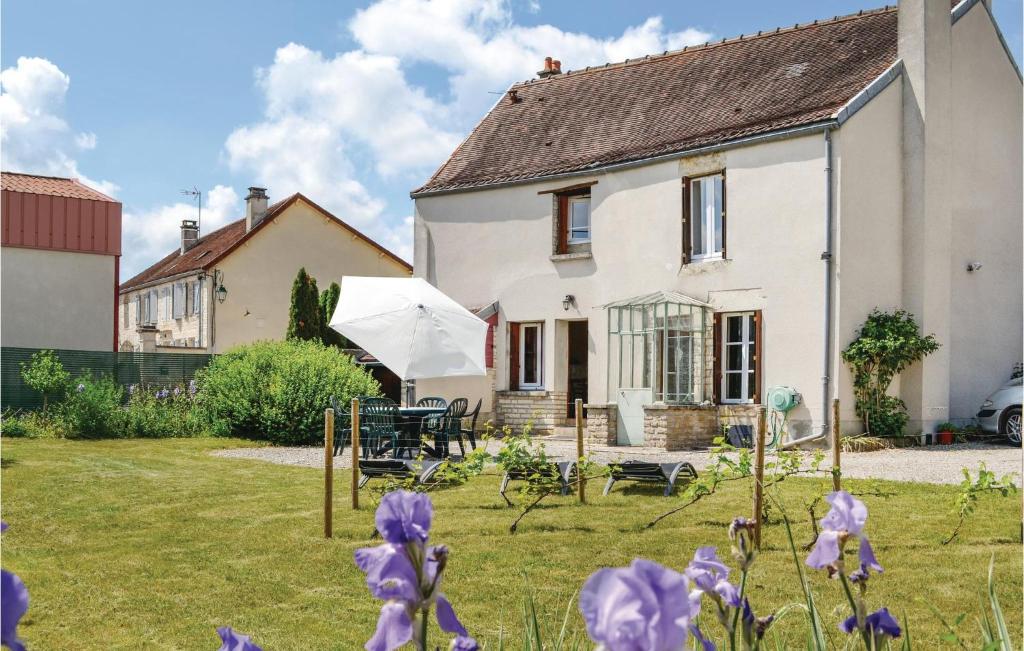 une maison blanche avec des fleurs violettes dans la cour dans l'établissement Nice Home In Landreville With Kitchen, à Landreville