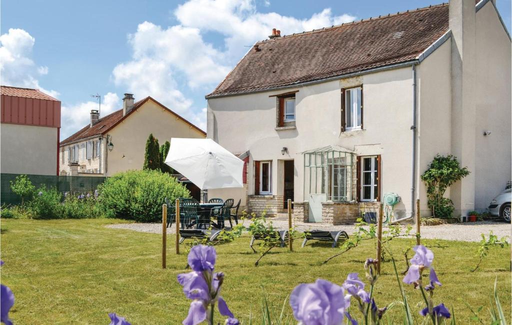 a white house with purple flowers in the yard at Holiday Home Landreville Rue De Crais in Landreville