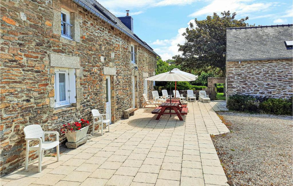 a patio with tables and chairs and an umbrella at 4 Bedroom Stunning Home In Clohars Carnoet in Clohars-Carnoët