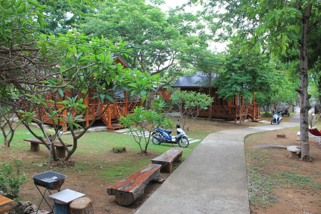 西昌島的住宿－錫江我家酒店，建筑前的公园,公园内有长椅和摩托车