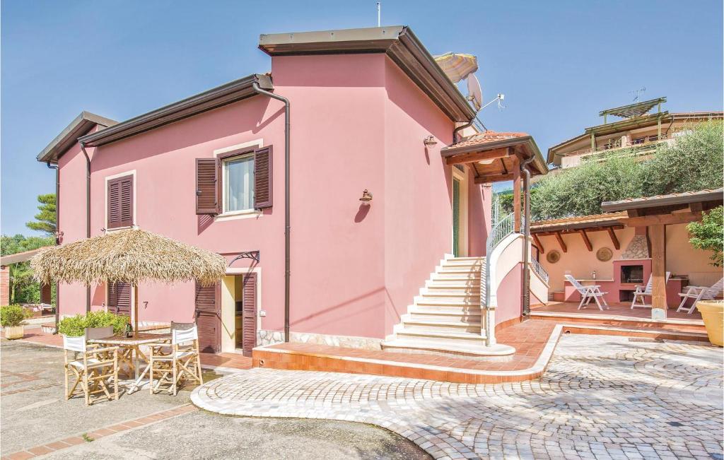 a pink house with stairs and a table and chairs at Villa Anna in Capo Vaticano