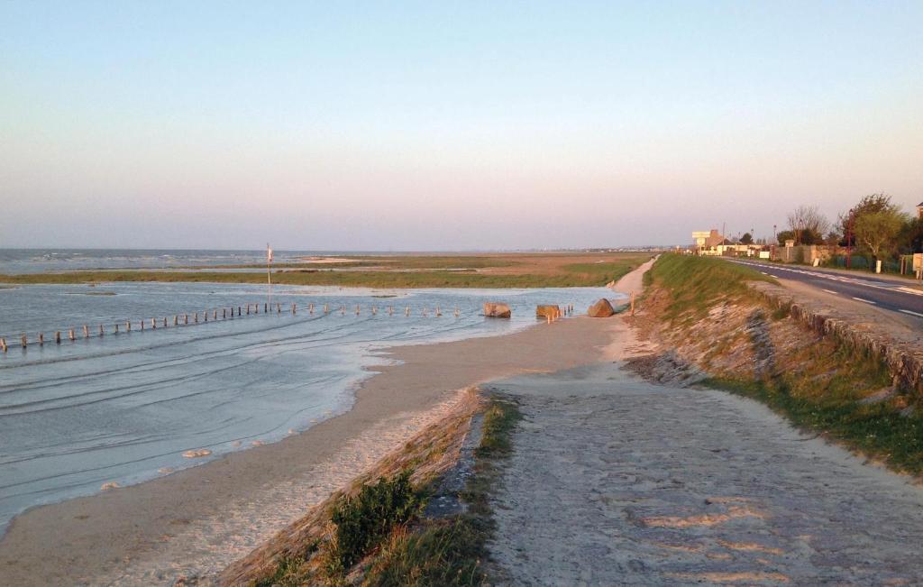 a beach with some animals walking on the sand at Gorgeous Apartment In Vildé-La-Marine in Vildé la Marine