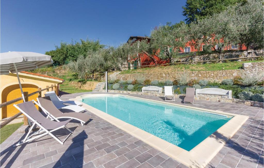 a swimming pool with two chairs and an umbrella at Lovely Home In Camaiore Lu With Outdoor Swimming Pool in Montemagno