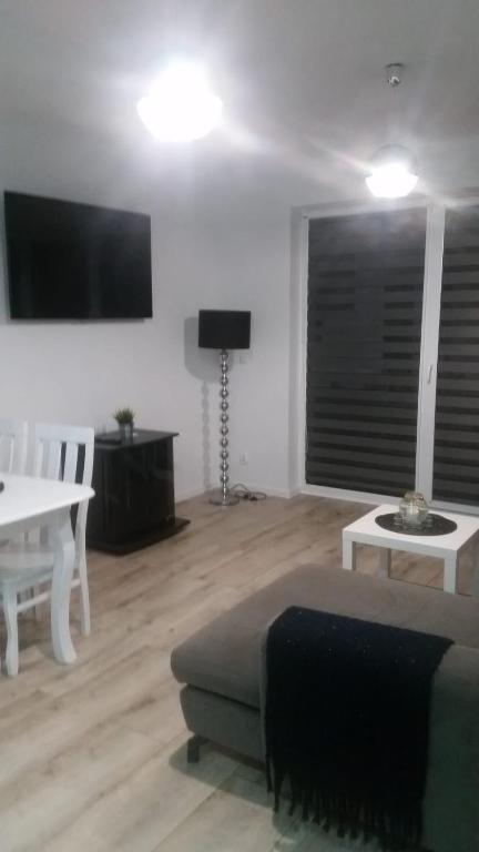 a living room with a couch and a table at Apartament Morski przy plazy in Darlowko