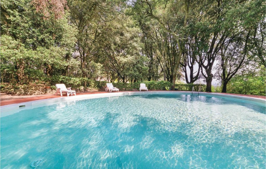 uma grande piscina com duas cadeiras e árvores em Barbaiano C em Monte San Savino