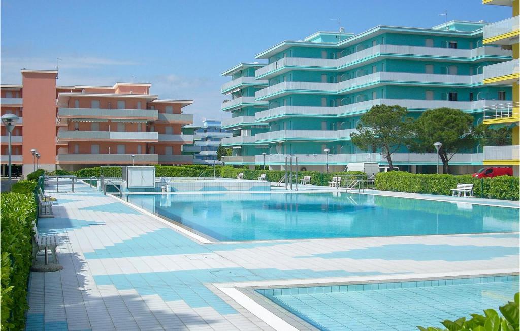 a swimming pool in front of a large building at Beautiful Apartment In Bibione With Outdoor Swimming Pool in Bibione