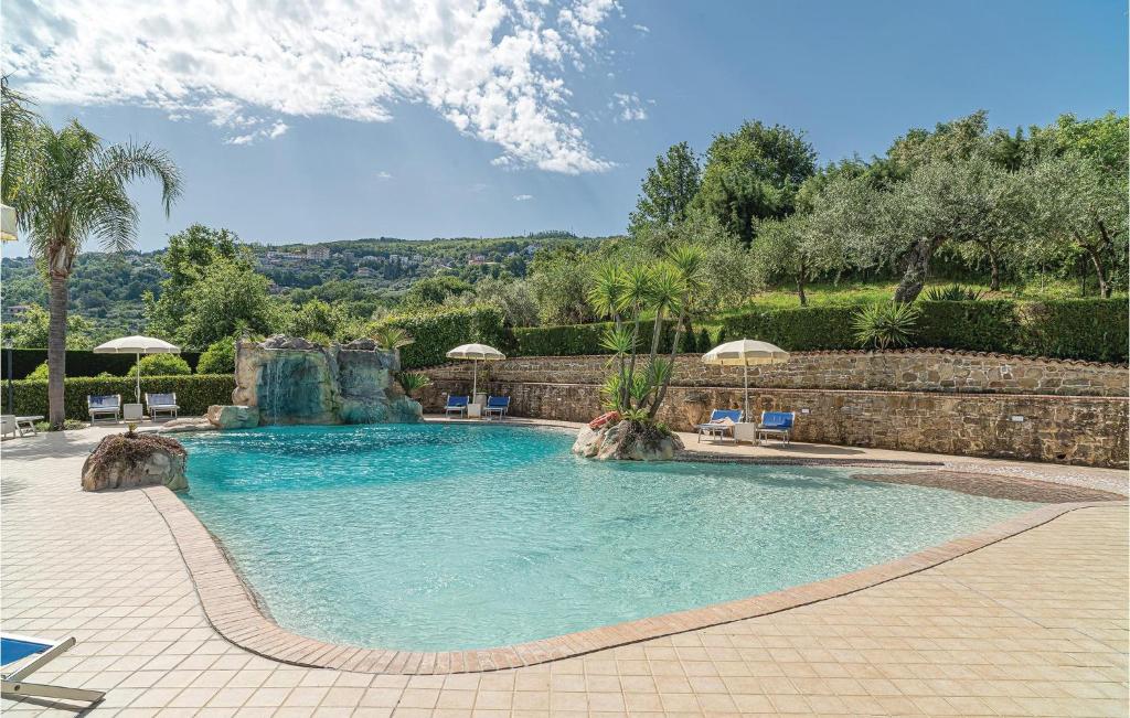 a swimming pool in a resort with chairs and umbrellas at Apt 7 in Laureana Cilento