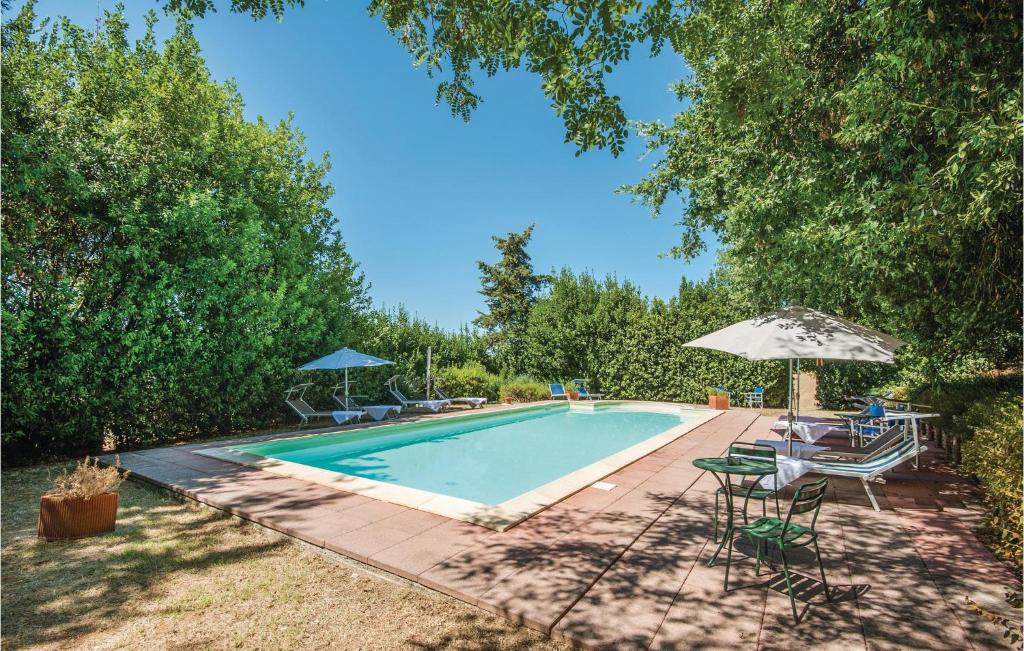 einen Pool mit Stühlen und einem Sonnenschirm in der Unterkunft Querce in San Pancrazio