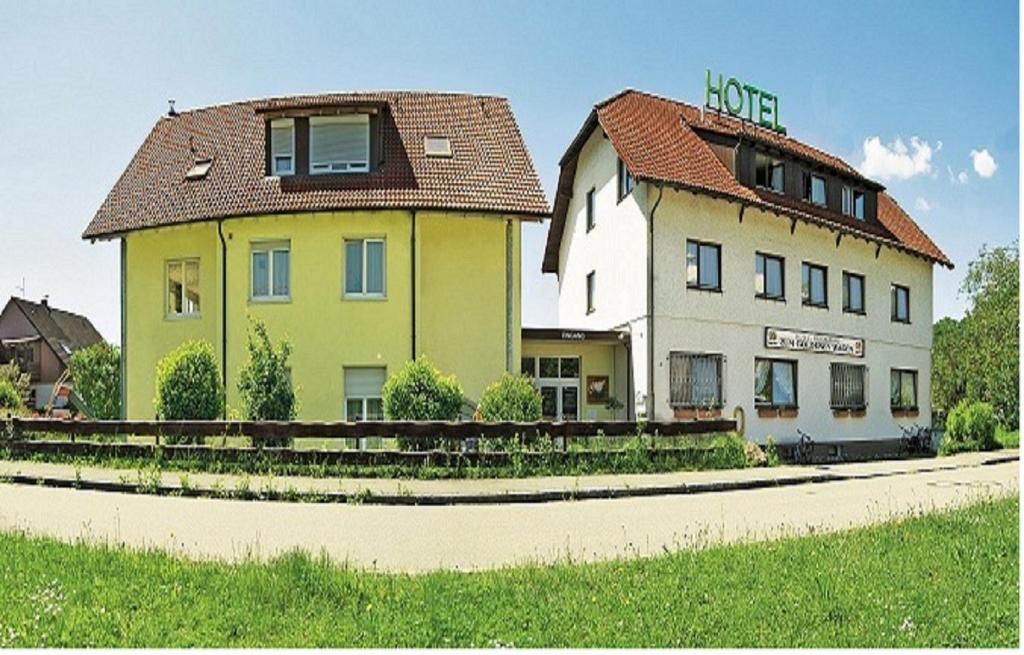 ein Haus und ein Gebäude am Straßenrand in der Unterkunft Hotel zum Goldenen Wagen in Maulburg