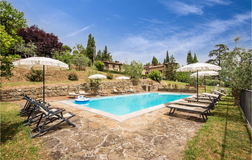 a swimming pool with lounge chairs and umbrellas at Beautiful Home In Capolona With 9 Bedrooms, Wifi And Private Swimming Pool in Capolona