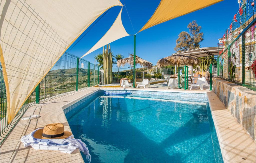 a swimming pool with a hat next to a building at Amazing Home In Tallante With House A Mountain View in Casas de Tallante