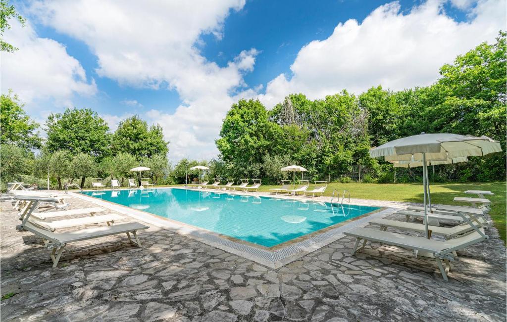 uma piscina com espreguiçadeiras e um guarda-sol em Sangiovese 6 em San Donato in Poggio