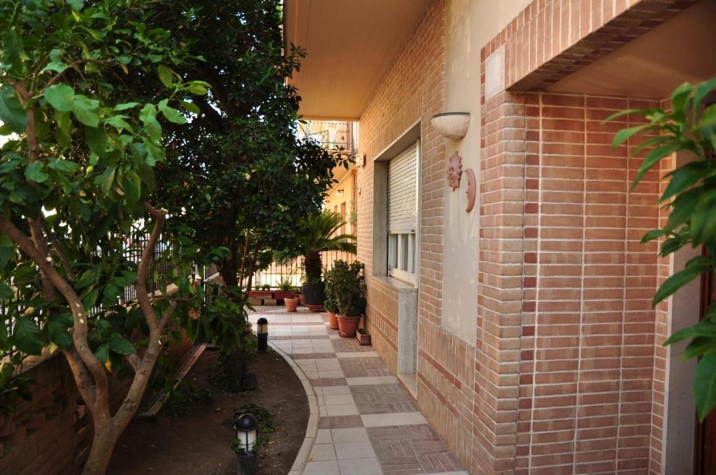 a brick walkway next to a building with trees at Domus Primavera in Scerne