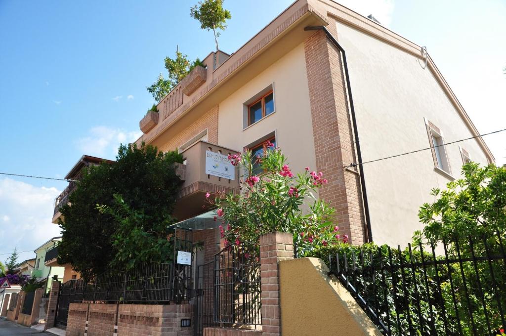 a building with a fence and flowers in front of it at Domus Primavera in Scerne