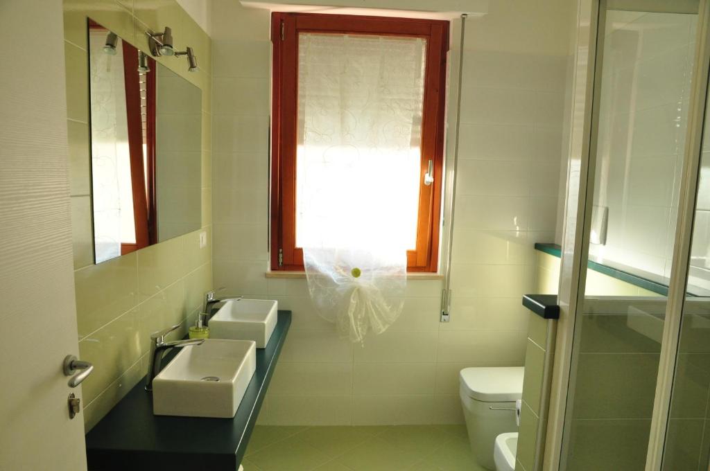 a bathroom with a sink and a toilet and a window at Domus Primavera in Scerne