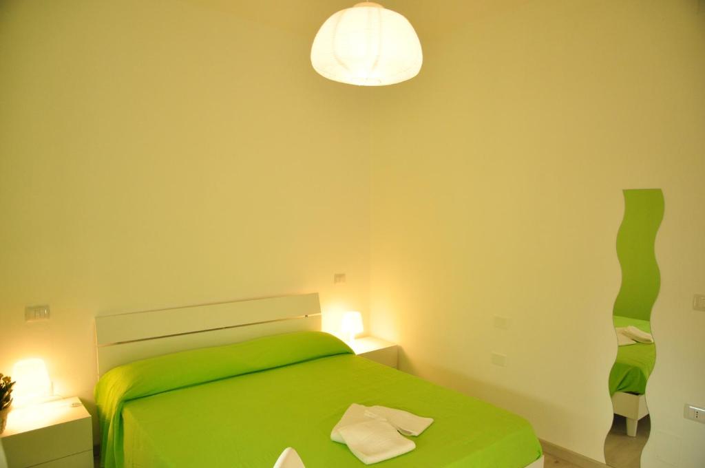 a green bedroom with a green bed and a lamp at Domus Primavera in Scerne