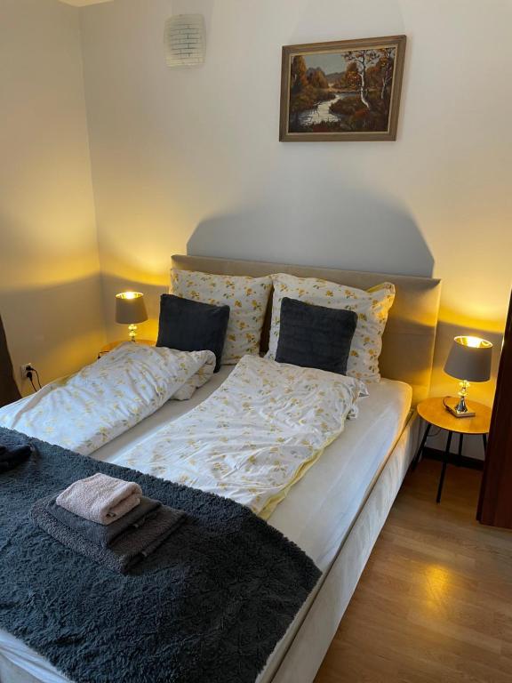 a bedroom with a bed and two lamps and a picture at Lorin Prestige Apartament in Elblag