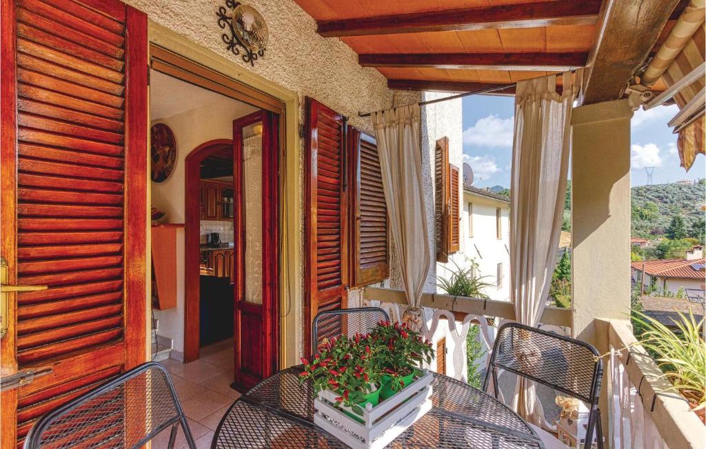 Corsanico-BargecchiaにあるBeautiful Apartment In Marignana lu With 2 Bedrooms And Wifiの家の上にテーブルと椅子付きのバルコニー