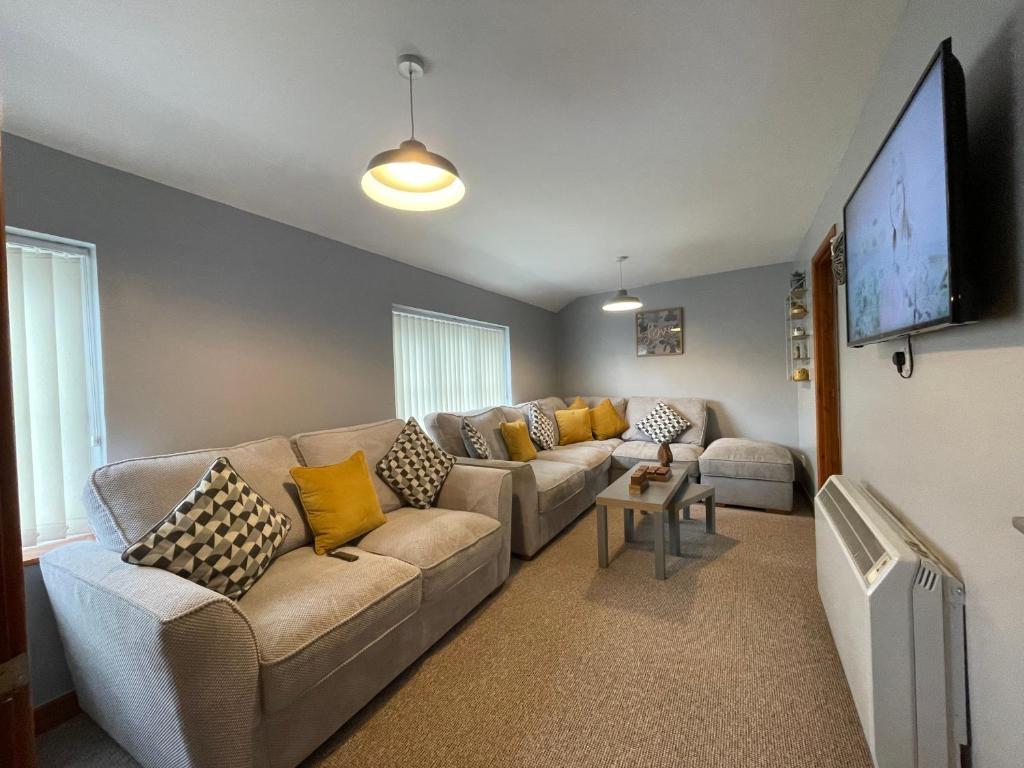 a living room with a couch and a flat screen tv at Westend Holiday Let 3 Brecon in Brecon