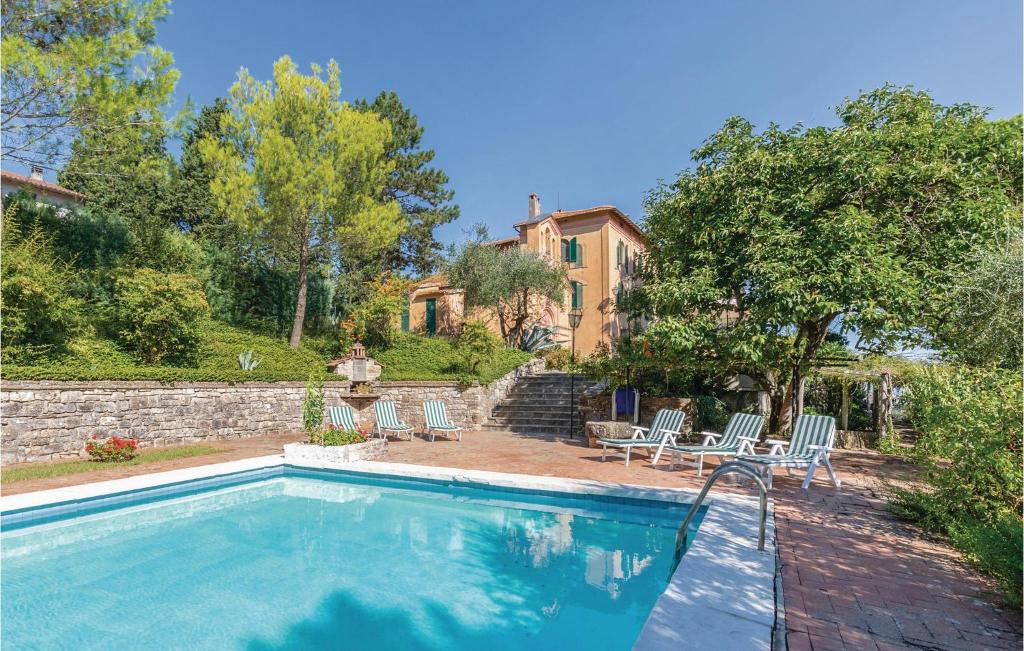 - une piscine avec des chaises et une maison dans l'établissement Villa Pasticci, à Collelungo
