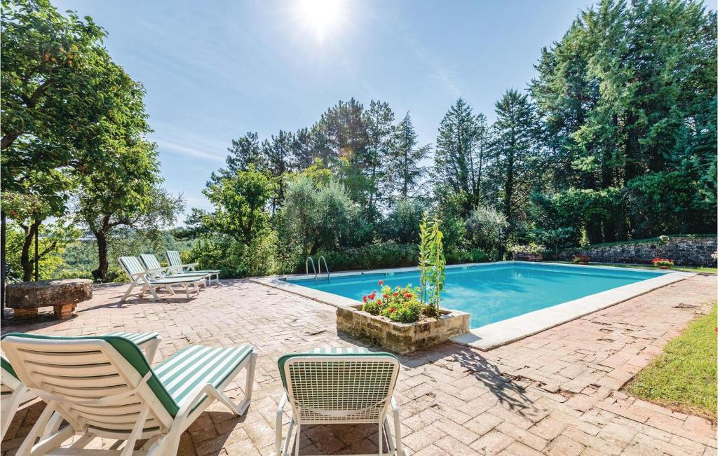patio z krzesłami i basenem w obiekcie Villa Pasticci w mieście Collelungo