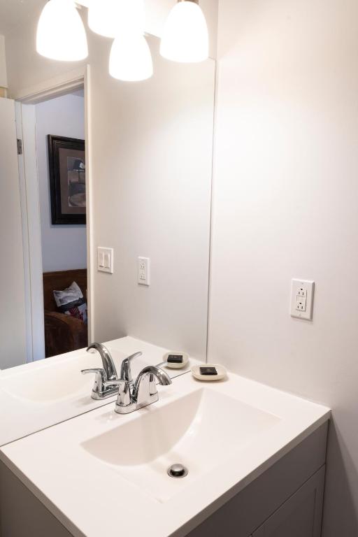 a bathroom with a white sink and a mirror at Schott's Lake Conference & Resort in Sundre