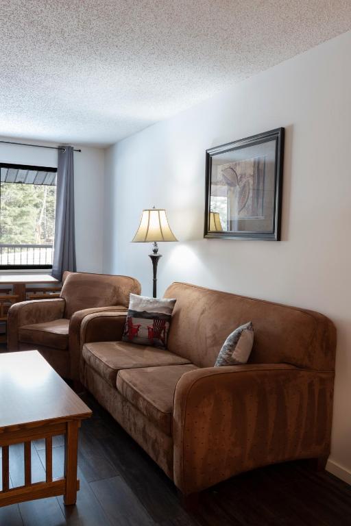 a living room with a couch and a table at Schott's Lake Conference & Resort in Sundre
